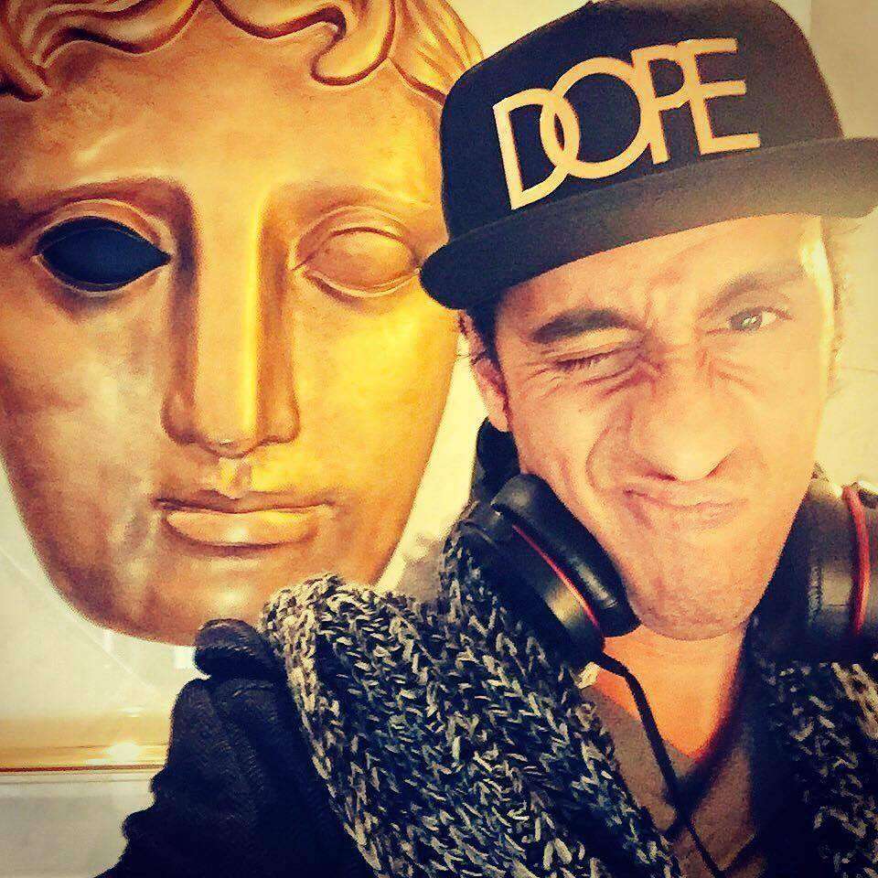 Muzz Khan posing with headphones and dope cap